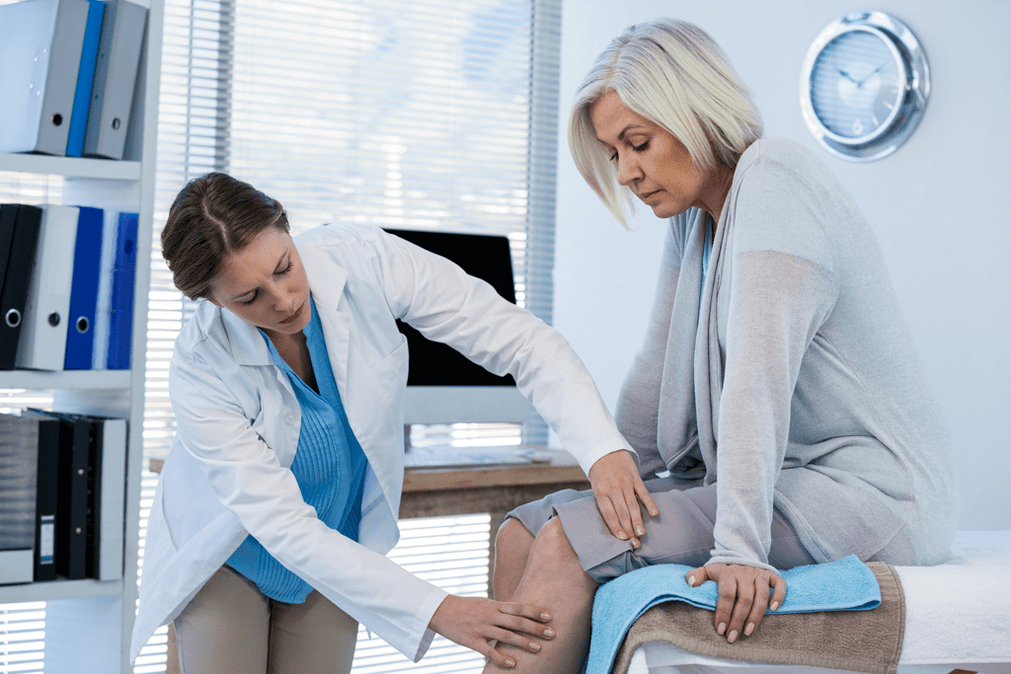 Ein Patient mit Arthrose, der eine Therapie benötigt, wird von einem Arzt untersucht